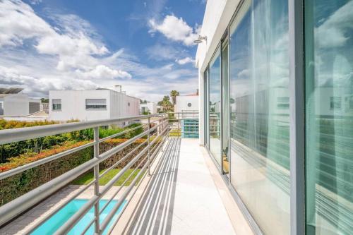 an open balcony with glass doors on a building at Moradia Palmela Village in Quinta do Anjo