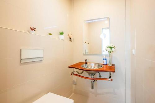 a bathroom with a sink and a mirror at Moradia Palmela Village in Quinta do Anjo
