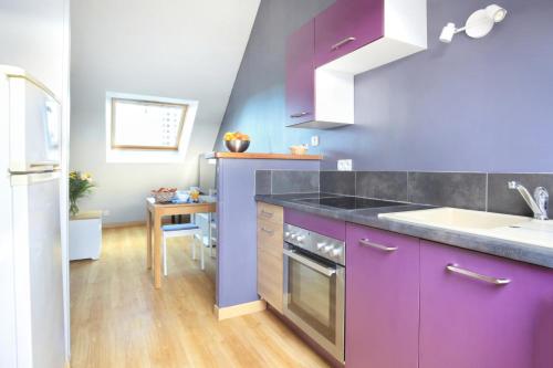 une cuisine avec des armoires violettes et un évier dans l'établissement Louis Philippe - Second Souffle - Cherbourg, à Cherbourg en Cotentin