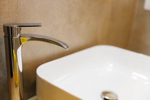 a bathroom with a sink and a faucet at Casa Nicole Elegante Monolocale a Collegno in Regina Margherita