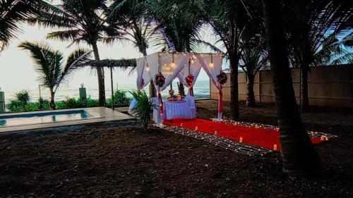 a table set up for a party with palm trees at Sea Facing Luxurious Private Pool Villa in Alibag