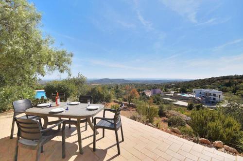a table and chairs on a patio with a view at Villa 3 Quartos, Piscina, AC, Vista Mar, Prestige For Home in Loulé