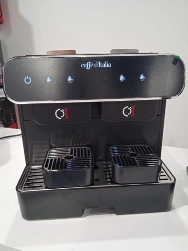 a black espresso machine sitting on a table at Il mulino foresteria in Parona