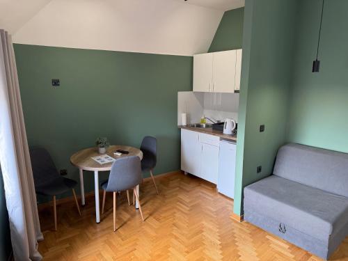a small room with a table and a bed and a kitchen at Aleksei Apartmani in Belgrade