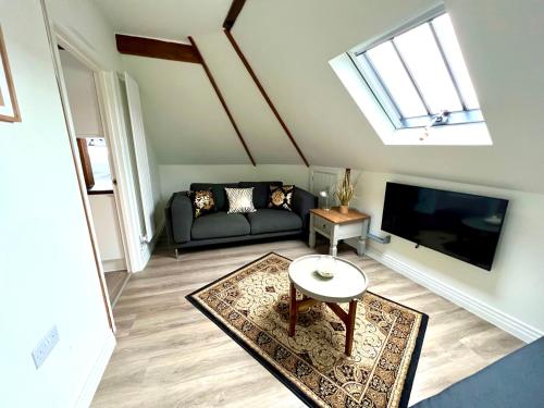 a living room with a couch and a tv at Glastonbury Secret Retreat - 1 BD Split-Level Apt, Sleeps 3 in Glastonbury