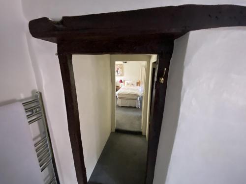 a hallway leading to a bedroom with a bed at Yallands Farmhouse in Taunton