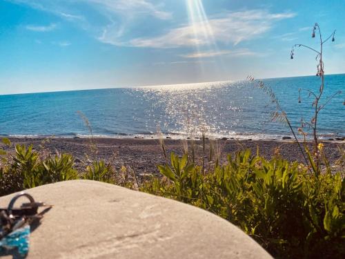 a beach with the sun shining on the water at B&B l'angoletto in Trebisacce