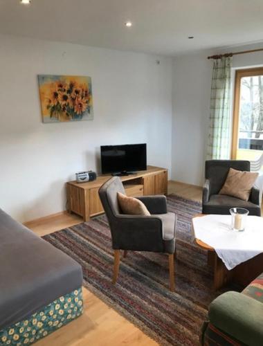 a living room with two chairs and a television at Winklgut Bacher in Uttendorf