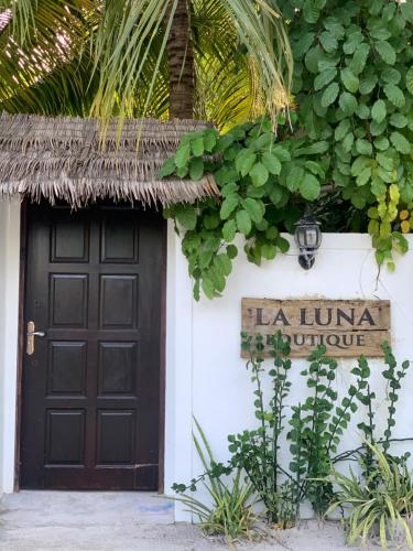 a black door and a sign on a white building at La Luna Boutique Dhangethi in Dhangethi