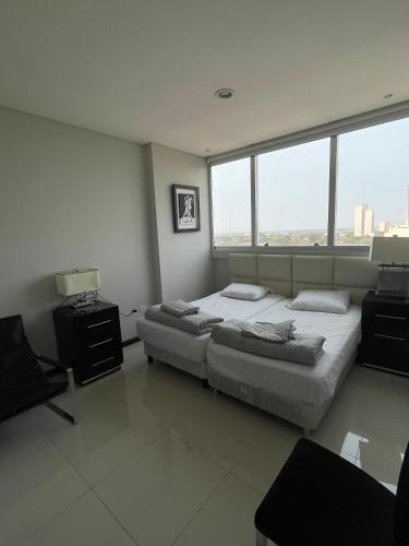 Un dormitorio con dos camas y dos ventanas. en Apartment Miami Tower Premium Villa Morra, en Asunción