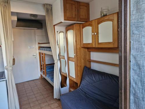 Cette petite chambre comprend un lit, des armoires et des lits superposés. dans l'établissement studio belle vue, à La Londe-les-Maures