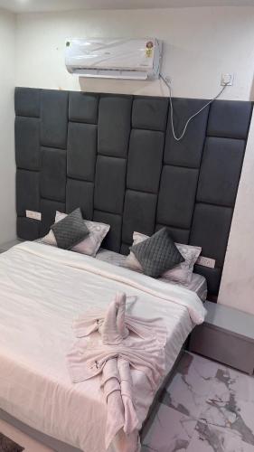 a bed with a black headboard with towels on it at Last Minute Deal @ Hotel Sunset in Orchha