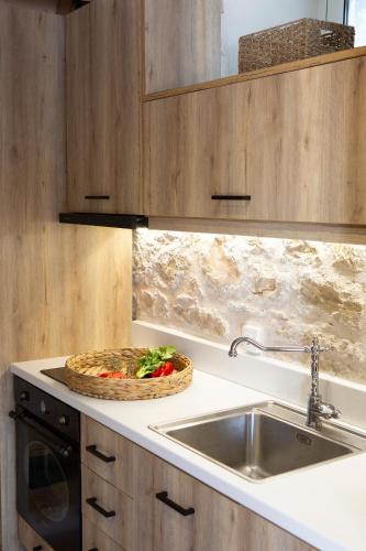 a kitchen with a sink and a basket of vegetables on a counter at E Loft in Meganisi