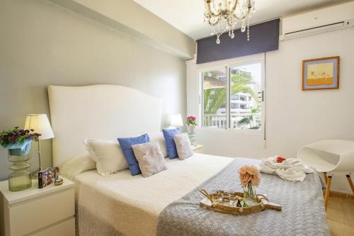 a bedroom with a large bed with a chandelier at Playa Arenal Grupo Terra De Mar in Calpe