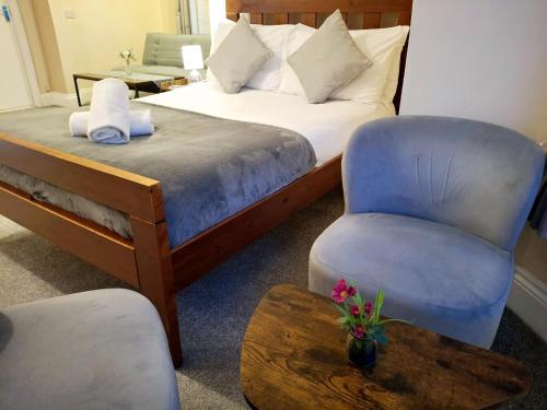 a hotel room with a bed and a chair at Inn By The Sea, Portsmouth - EN SUITE Rooms with Sea View Possible, parking EV 22kW in Portsmouth