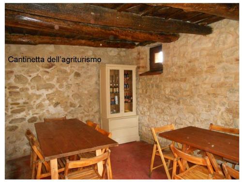 un comedor con 2 mesas y un armario de botellas de vino en Agriturismo Il Palmarone, en Rotella