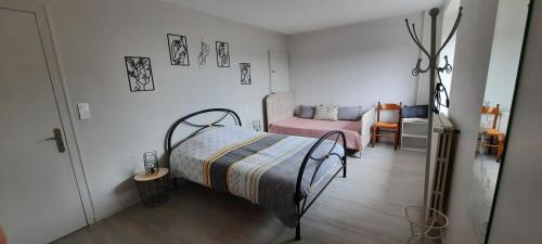 a bedroom with a bed and a table and chair at chambre d'hôtes des roseaux in La Forêt-sur-Sèvre