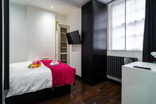 ein Schlafzimmer mit einem Bett mit einer roten Decke in der Unterkunft Stylish 2 bedroom apartment in Shoreditch - London in London
