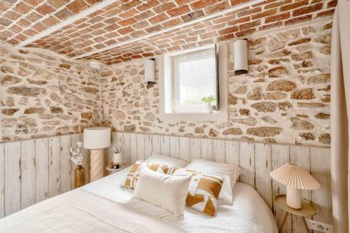 une chambre avec un mur de briques et un lit dans l'établissement 2mn Walk Train Station - Paris 10mn - Free Private Parking - From 1 to 8 Guests - Souplex - All equipped - Completely Renovated, à Montmagny