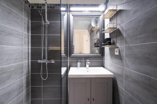 une salle de bain avec un lavabo et une douche avec un miroir dans l'établissement T2 Rez de Jardin face à la mer 100m plages Six-Fours-les-Plages, à Six-Fours-les-Plages