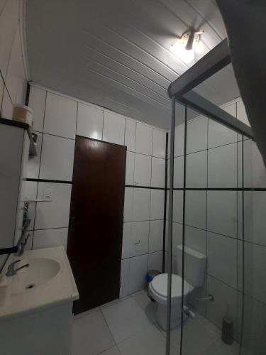 a small bathroom with a toilet and a sink at Pousada Ana in São Gabriel