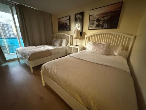 a hotel room with two beds and a window at Family Stay Ocean Reserve Resort Sunny Isles in Sunny Isles Beach