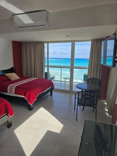a bedroom with a bed and a view of the ocean at Cancun Beach & Nightlife Paradise SALVIA CONDOMINIUMS in Cancún