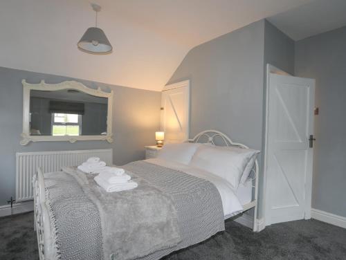 a bedroom with a bed with towels on it at Islwyn in Llandudno Junction