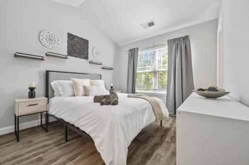 a white bedroom with a bed with a teddy bear on it at Garage w/ Veranda & Washer + Dryer in Atlanta