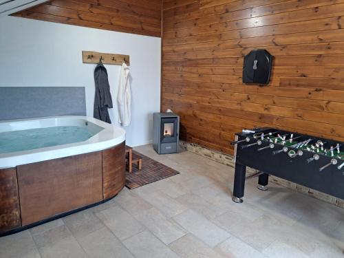 a bathroom with a tub and a wood wall at Kuča za odmor Stina in Slavetić
