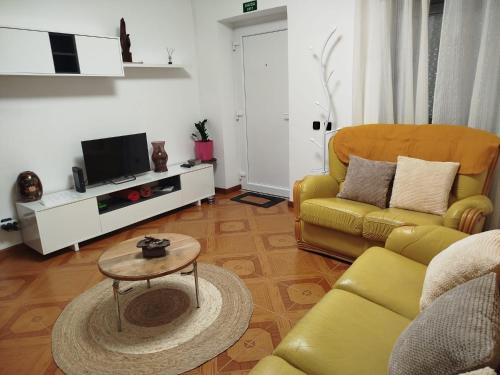 a living room with a yellow couch and a table at Casa da Calçada - Casa Inteira in Seia