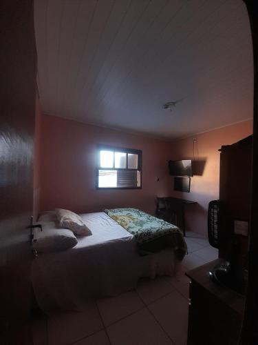 a bedroom with a bed and a window at Pousada Ana in São Gabriel