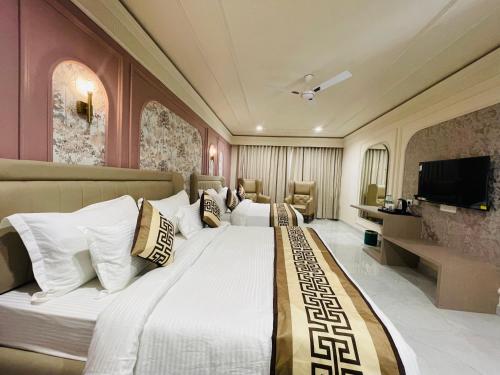a hotel room with a large bed and a television at Krishna Resort Pushkar in Pushkar