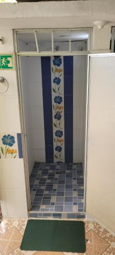 a bathroom with a shower with a tile floor at Hostal Villa del Río Las Brisas in Villavieja