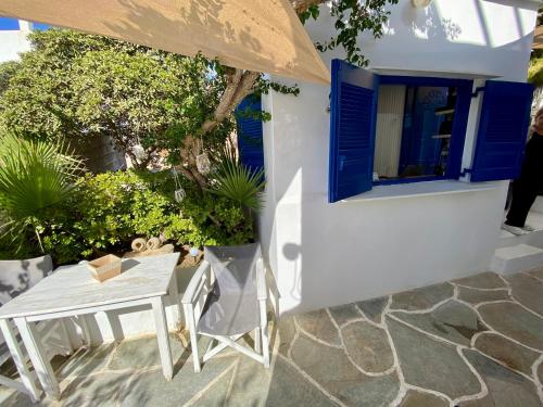 a table and an umbrella in front of a house at Serene Hill in Naousa