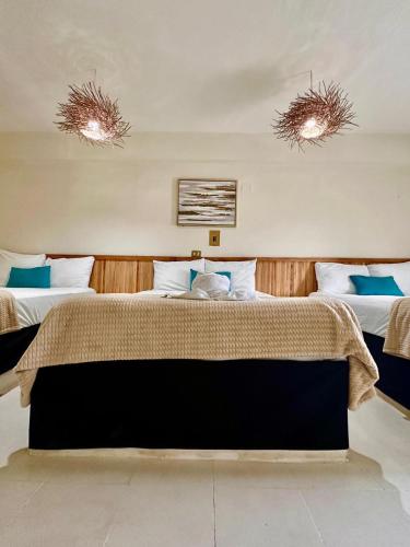 a bedroom with two beds and two lights on the ceilings at Hotel cacao spa cozumel in Cozumel