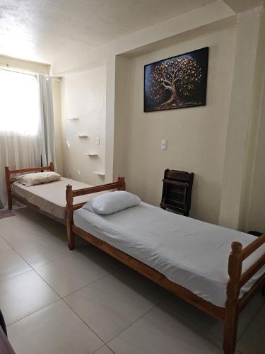 two beds sitting in a room with a window at Estúdio Central 76 in Ponta Grossa