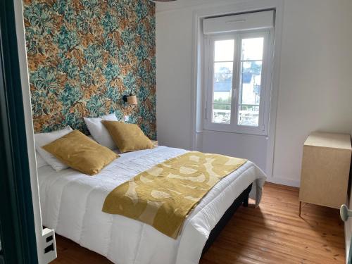 une chambre avec un lit avec un papier peint fleuri dans l'établissement La villa Alixel, à Pléneuf-Val-André