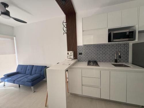 a kitchen with white cabinets and a blue chair at Ocean Dream Apartments E1-A1 in San Juan del Sur