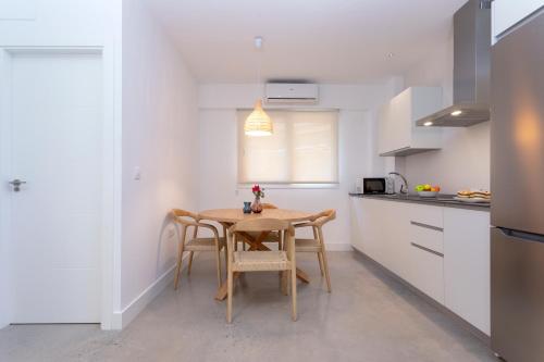 a kitchen with a table and chairs in a room at Apartamentos Costa Tropical by Rent Me in Motril