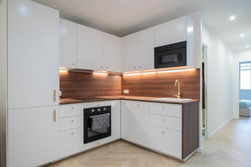 une cuisine avec des armoires blanches et un four à plaques de cuisson dans l'établissement Beautiful 3 rooms, Carré d 'Or, à Nice