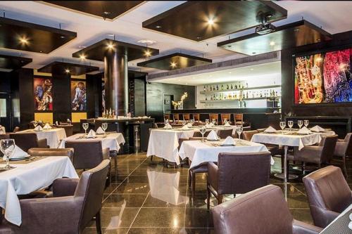 a restaurant with white tables and chairs and a bar at Flat Hotel Millennium in Manaus
