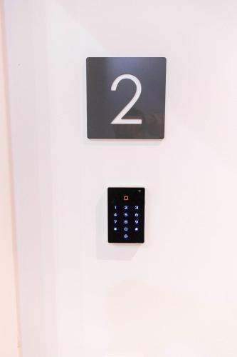 a remote control on a white door with the number two at Apartamentos Julio Burell, 74 CAROLA in Linares
