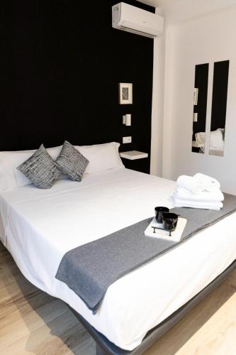 a bedroom with a white bed with a black wall at Apartamentos Julio Burell, 74 CAROLA in Linares