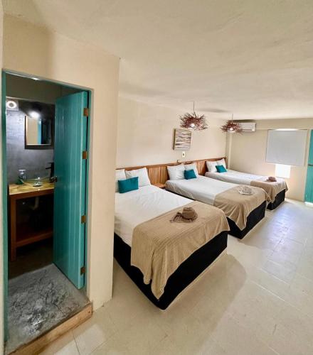 a room with two beds and a sink in it at Hotel cacao spa cozumel in Cozumel