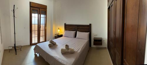 a bedroom with a bed with two towels on it at Apto con vistas Virgen del Carmen in El Rompido