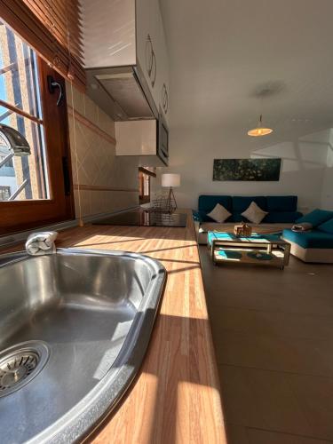 a kitchen with a stainless steel sink and a living room at Apto con vistas Virgen del Carmen in El Rompido