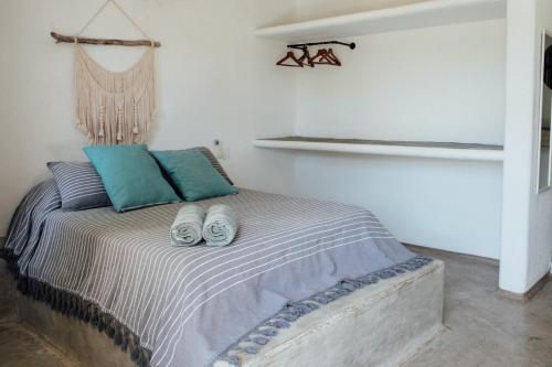 a bedroom with a bed with two slippers on it at Casa Kâi in Brisas de Zicatela