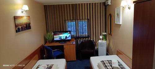 a hotel room with a tv and a room at ZAJAZD ALBATROS Rzeszów SPA in Rzeszów