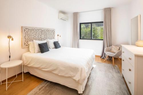 a white bedroom with a large bed and a window at Villa V2 VALE DO LOBO BEACH & GOLF in Vale do Lobo